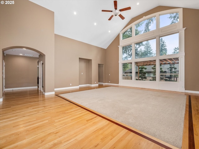 1303 NE 147th Ave, Vancouver, WA 98684 - unfurnished living room featuring high vaulted ceiling, arched walkways, a ceiling fan, wood finished floors, and baseboards