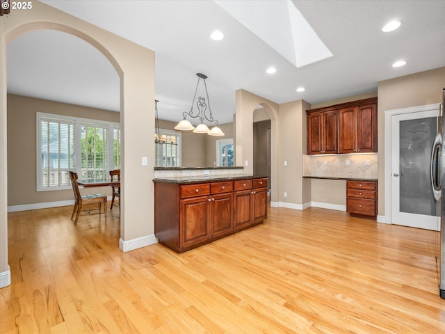 1303 NE 147th Ave, Vancouver, WA 98684 - kitchen featuring arched walkways, tasteful backsplash, light wood finished floors, recessed lighting, and baseboards