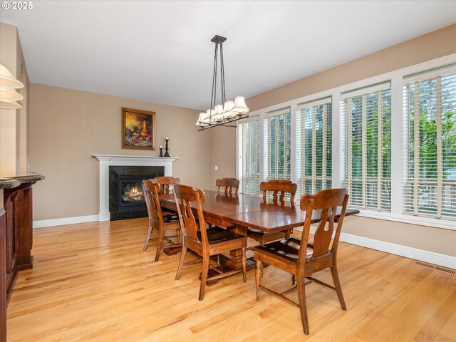 1303 NE 147th Ave, Vancouver, WA 98684 - dining area with baseboards, a fireplace, light wood-style floors, and a chandelier