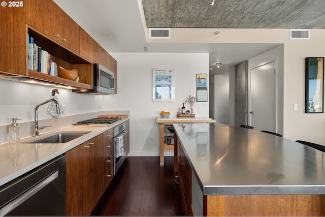 1926 W Burnside St Unit 1401, Portland, OR 97209 - kitchen featuring stainless steel countertops, a sink, stainless steel appliances, brown cabinets, and modern cabinets
