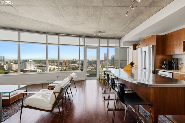 1926 W Burnside St Unit 1401, Portland, OR 97209 - kitchen with stainless steel counters, appliances with stainless steel finishes, a city view, rail lighting, and brown cabinets