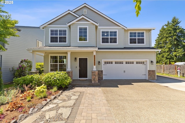 12800 Joys Dr, Oregon City, OR 97045 - view of front facade with concrete driveway, an attached garage, stone siding, and covered porch