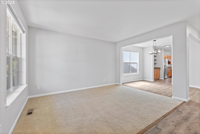 12800 Joys Dr, Oregon City, OR 97045 - unfurnished living room with a chandelier, baseboards, and wood finished floors