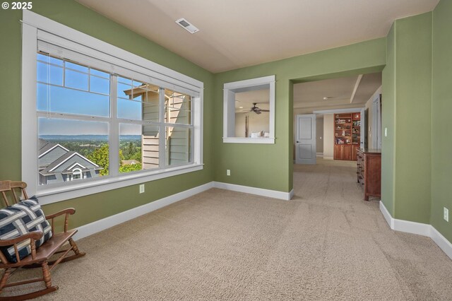 unfurnished room with carpet floors, baseboards, and a ceiling fan