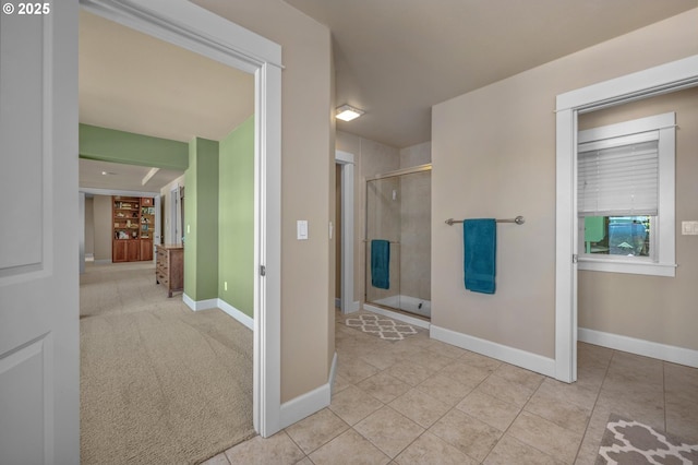 full bath featuring a stall shower, tile patterned floors, and baseboards