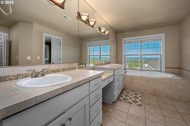 full bath with tile patterned flooring, vanity, and a garden tub