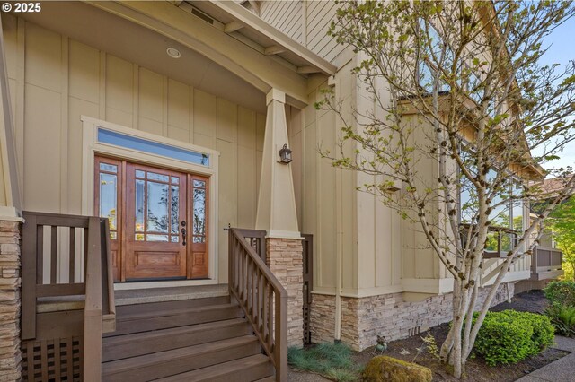 property entrance with stone siding and board and batten siding