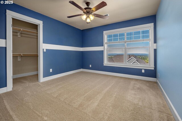 unfurnished bedroom with carpet, baseboards, a closet, and a spacious closet