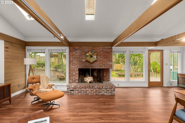 sitting room featuring wooden walls, a fireplace, hardwood / wood-style floors, and plenty of natural light