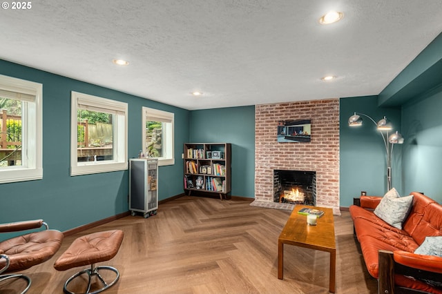 living room featuring a textured ceiling, a fireplace, and light parquet floors