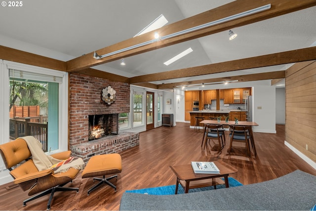 living room with dark wood-type flooring, lofted ceiling with beams, and a fireplace