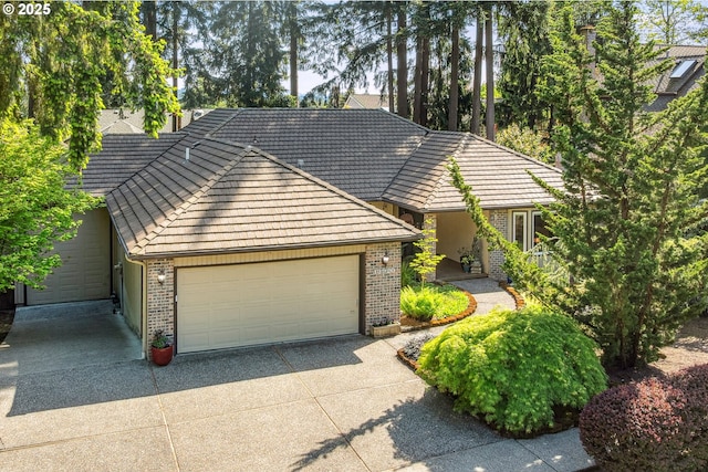 view of front of property featuring a garage, driveway, and brick siding