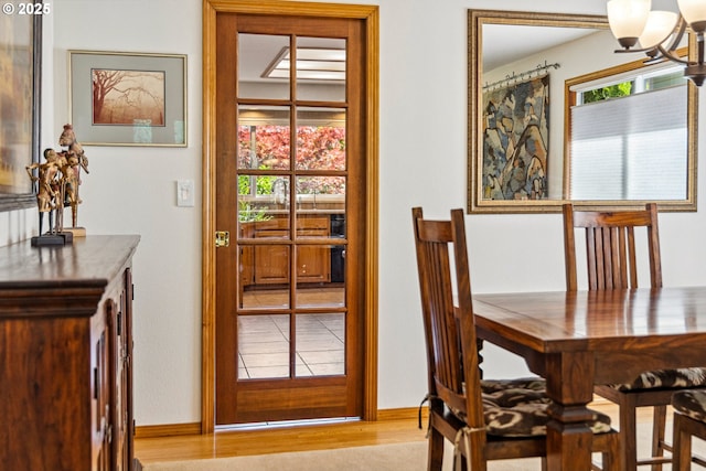 dining space with an inviting chandelier, baseboards, and wood finished floors