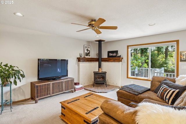 carpeted living area with recessed lighting, a wood stove, and ceiling fan