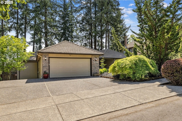 ranch-style home with an attached garage, brick siding, a tile roof, and concrete driveway