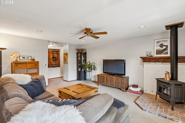 living area featuring recessed lighting, a wood stove, carpet, and a ceiling fan