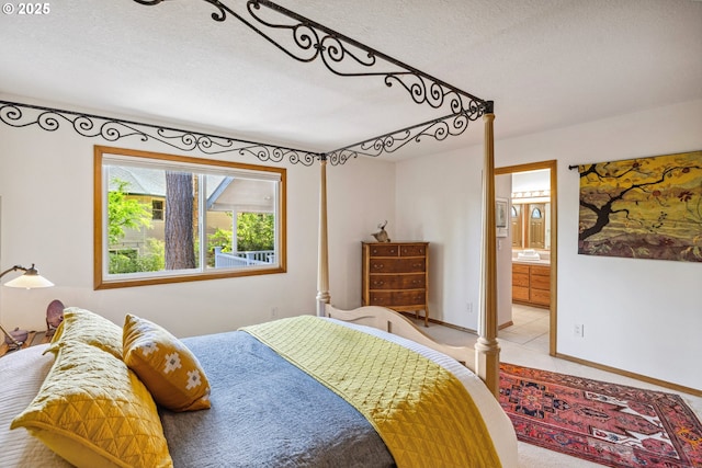 bedroom with carpet floors, a textured ceiling, and connected bathroom
