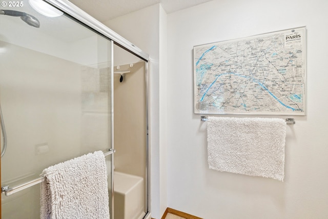 bathroom with baseboards and a stall shower
