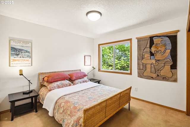 bedroom featuring baseboards, a textured ceiling, and light carpet