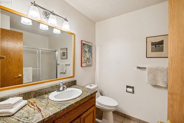 full bathroom featuring a textured ceiling, tile patterned flooring, a stall shower, vanity, and toilet