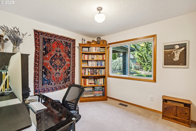 carpeted home office featuring visible vents, a textured ceiling, and baseboards