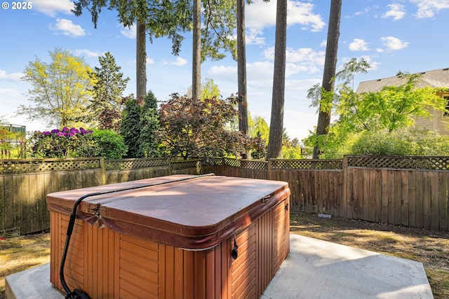 exterior space with a fenced backyard and a hot tub