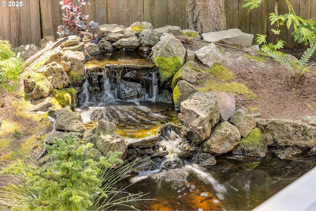 exterior details with fence and a garden pond