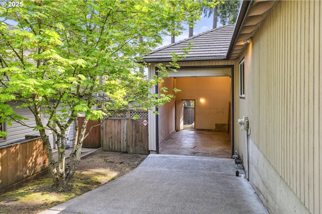 view of property exterior featuring fence, a gate, and a tile roof
