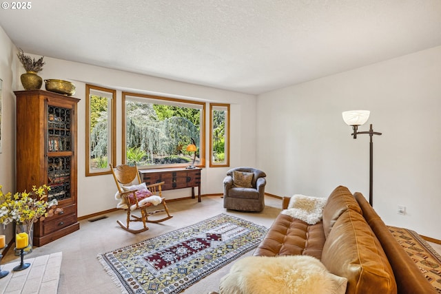 living room featuring baseboards, carpet flooring, a textured ceiling, and visible vents