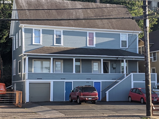 view of property with a porch and a garage