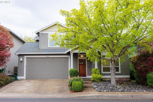 view of front of property featuring concrete driveway, an attached garage, and roof with shingles