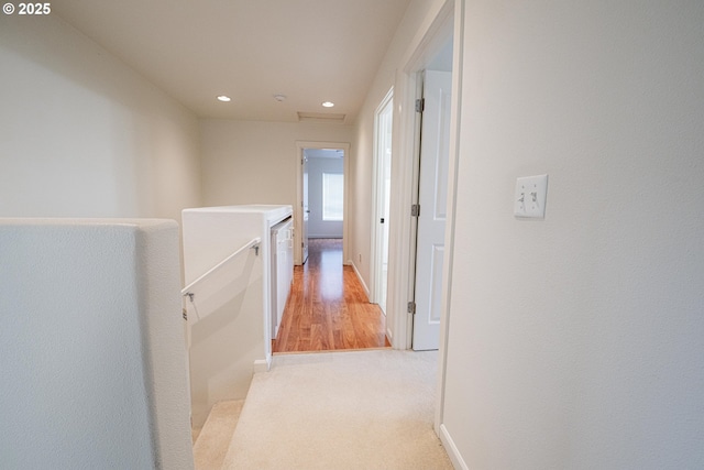 hallway with recessed lighting, baseboards, and light carpet