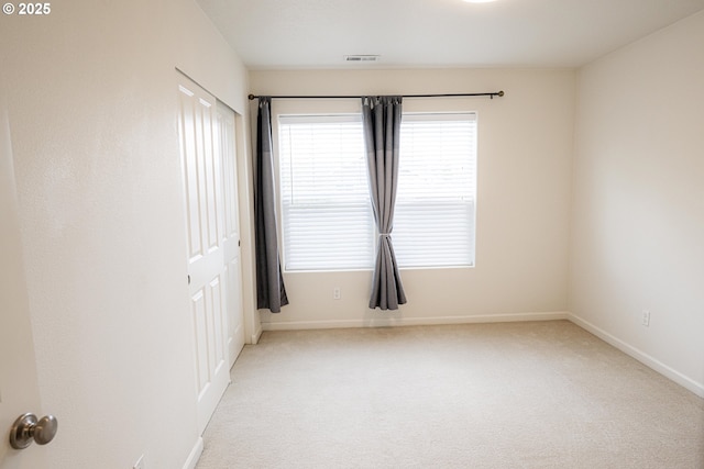 unfurnished room with visible vents, carpet flooring, and baseboards