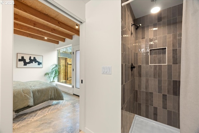 bathroom with beamed ceiling, a tile shower, and finished concrete floors