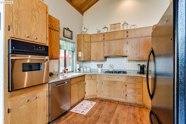 2407 Hawkins Ln, Eugene, OR 97405 - kitchen with stainless steel appliances, vaulted ceiling, backsplash, light wood-type flooring, and light countertops