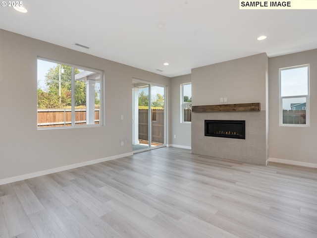 unfurnished living room with visible vents, baseboards, and wood finished floors