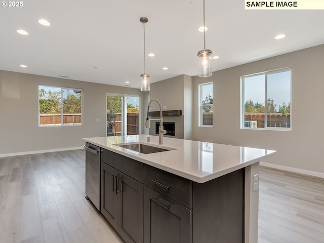 kitchen with light countertops, baseboards, light wood-type flooring, and a sink