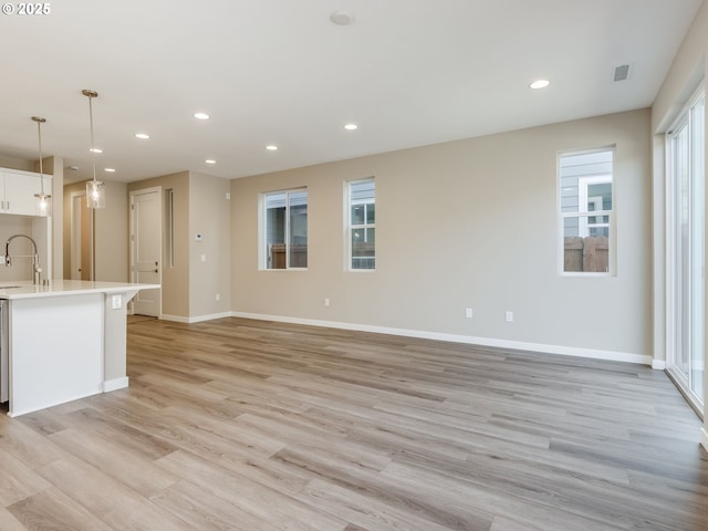 728 NW 178th Way, Ridgefield, WA 98642 - unfurnished living room with light wood-type flooring, recessed lighting, a sink, and baseboards