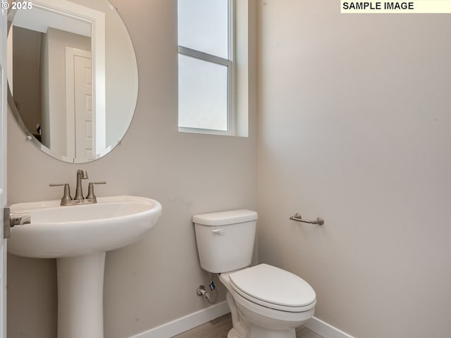 bathroom featuring baseboards, toilet, and wood finished floors