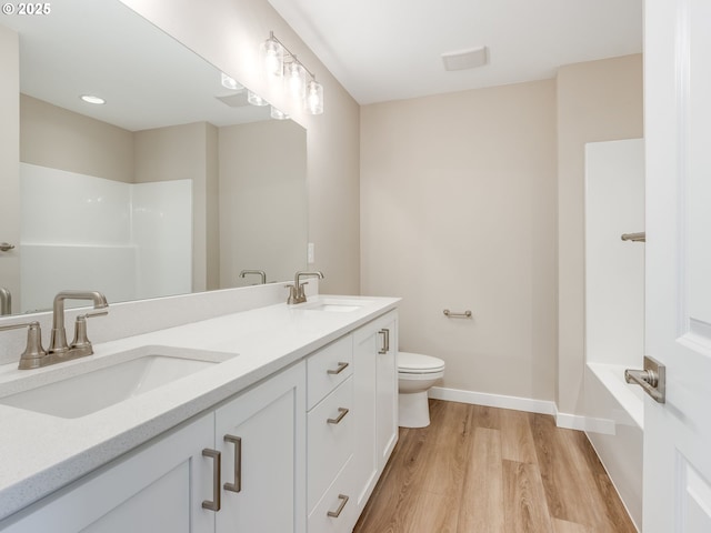 728 NW 178th Way, Ridgefield, WA 98642 - bathroom featuring wood finished floors, toilet, double vanity, baseboards, and a shower