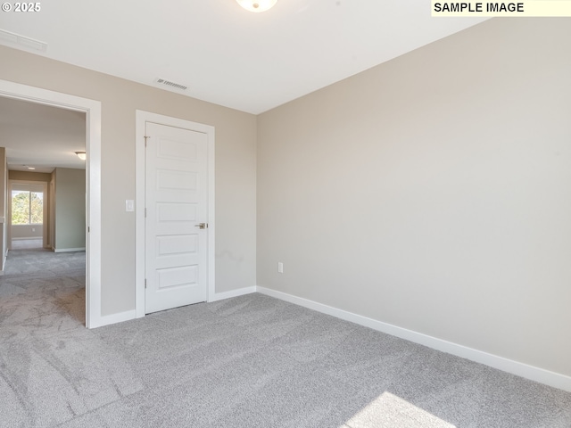 unfurnished room with visible vents, baseboards, and carpet flooring