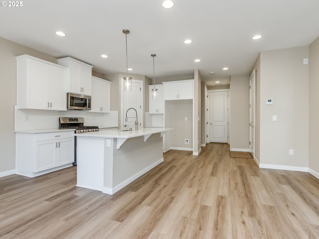 728 NW 178th Way, Ridgefield, WA 98642 - kitchen featuring appliances with stainless steel finishes, light wood-type flooring, white cabinetry, recessed lighting, and a sink