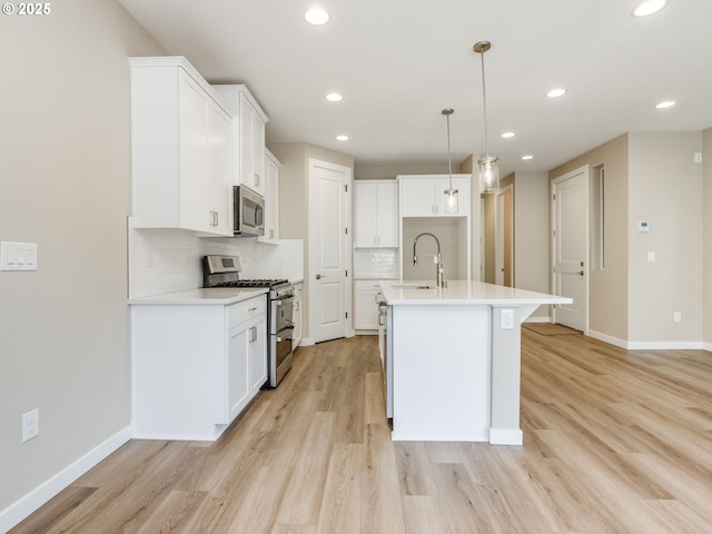 728 NW 178th Way, Ridgefield, WA 98642 - kitchen with stainless steel appliances, a sink, baseboards, light wood-style flooring, and decorative backsplash