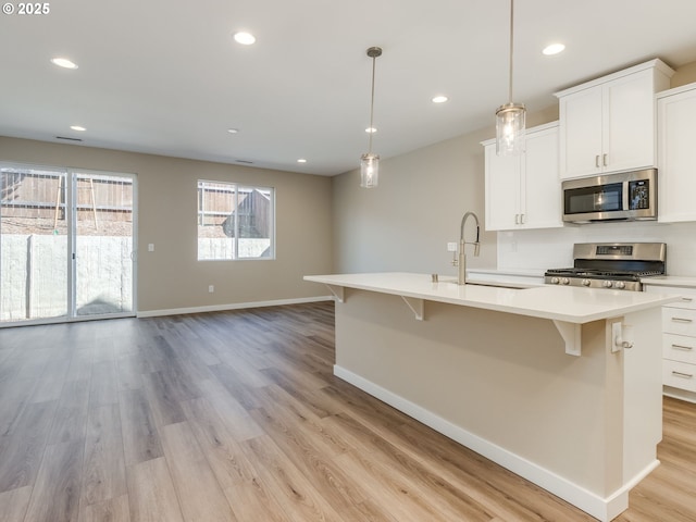 728 NW 178th Way, Ridgefield, WA 98642 - kitchen with appliances with stainless steel finishes, a sink, light wood-style floors, baseboards, and light countertops