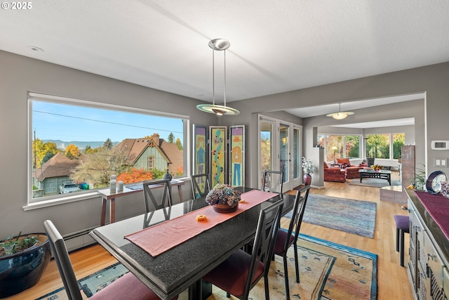 dining space featuring a textured ceiling and light wood-type flooring