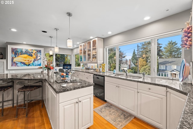 kitchen featuring sink, light hardwood / wood-style flooring, white cabinets, and dishwasher