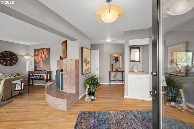 entrance foyer with a fireplace, light hardwood / wood-style floors, and a textured ceiling