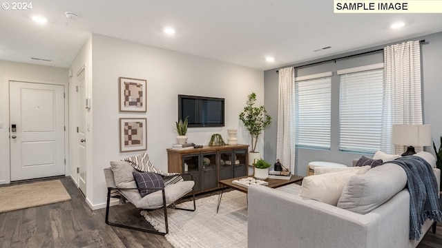 living area featuring baseboards, wood finished floors, visible vents, and recessed lighting