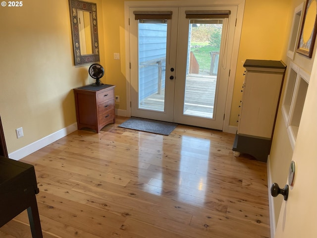 doorway to outside with light wood finished floors, french doors, and baseboards