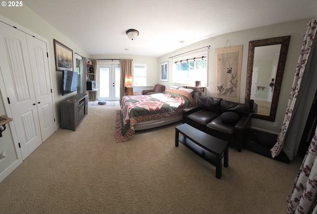 bedroom featuring french doors, light carpet, and a closet